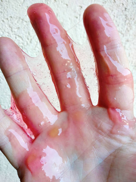 istock Red sticky slime goo on hand and fingers 1047017564