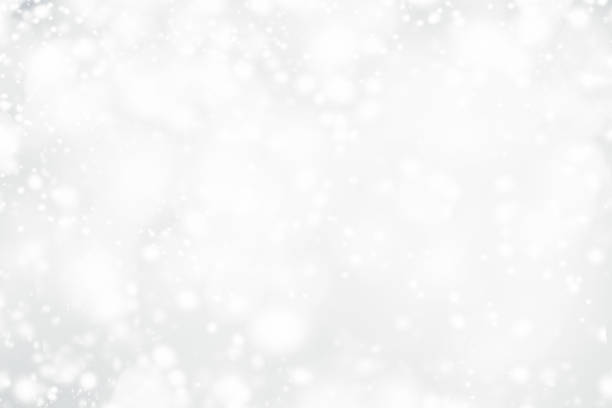 istock White Christmas abstract bokeh background with snowflake and silver glittering bokeh stars. Festive Glowing blurred lights