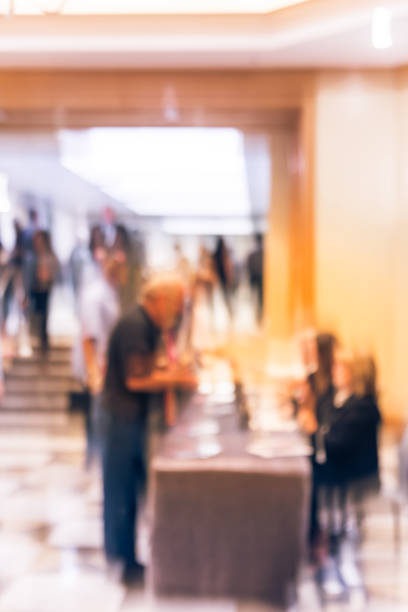 istock Blurry background side view participants at conference check-in table near hotel staircase 1047017734