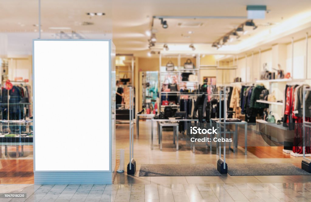 Clothes shop entrance with empty billboard mockup Clothes shop entrance with empty billboard mockup to place text, logo or advertisement Shopping Mall Stock Photo