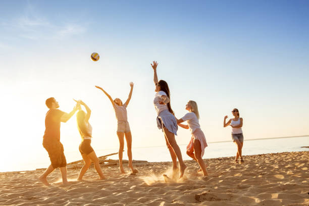 istock Group of friends plays ball sunset beach 1047023700