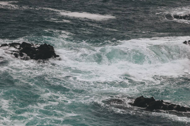 istock dramatic shot of blue ocean waves crashing on rocks 1047024336