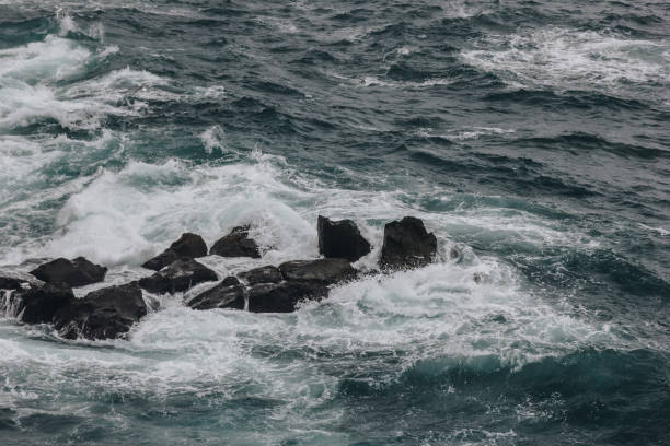 istock dramatic shot of ocean waves crashing on rocks for background 1047024374