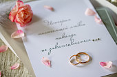 Two Golden Wedding Rings, box of chocolates and a wedding invitation, an inscription that the story of true love never ends, close-up.