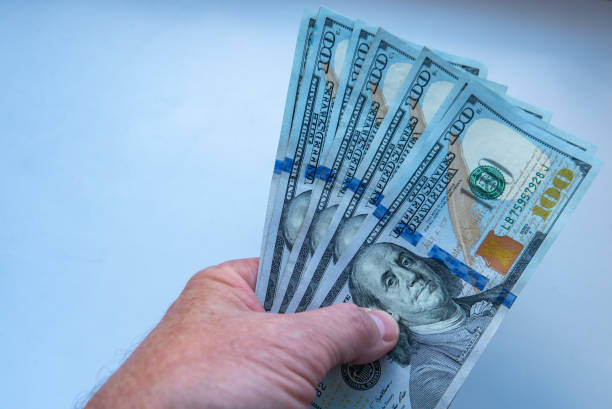 istock hand holding money, us dollars 1047027474