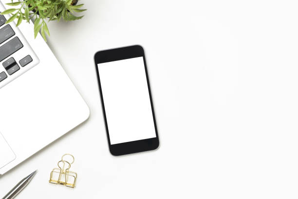 istock Smartphone with blank screen is on top of white table. Top view with copy space, flat lay.tha 1047027608