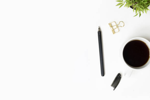 istock White minimalist office desk table with cup of coffee and pen.  Top view with copy space, flat lay. 1047027622