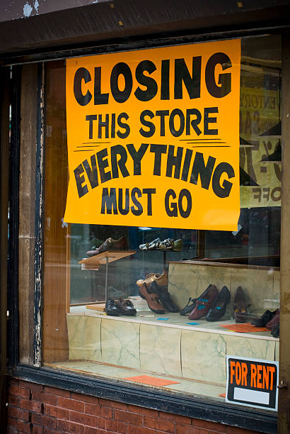 Closing down store sign in yellow Going out of business sign on shoe store window closing down sale stock pictures, royalty-free photos & images