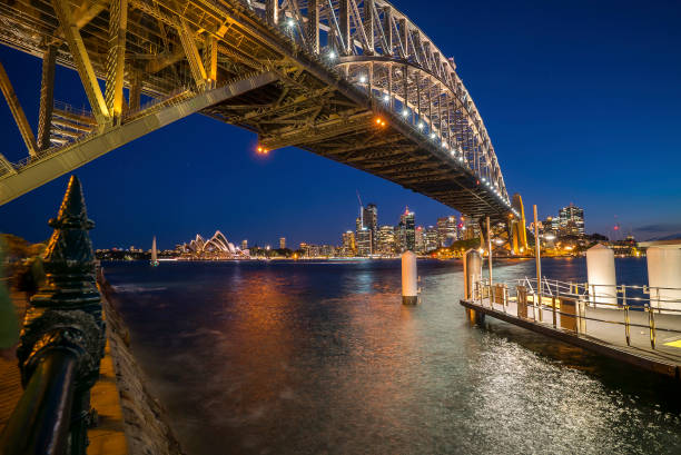 abenddämmerung in sydney - sydney harbor australia financial district cruise ship stock-fotos und bilder