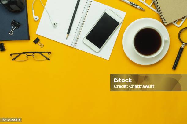 Table Top View Aerial Image Of Accessories Office Desk Background Conceptflat Lay Of Variety Object The Mobile Phone Pen And Coffee With Earphone On Modern Rustic Yellow Paper With Copy Space Stock Photo - Download Image Now