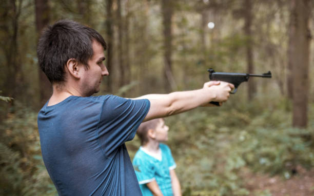 istock Shooting Lesson. Man is Aiming From Pneumatic Pistol 1047038718