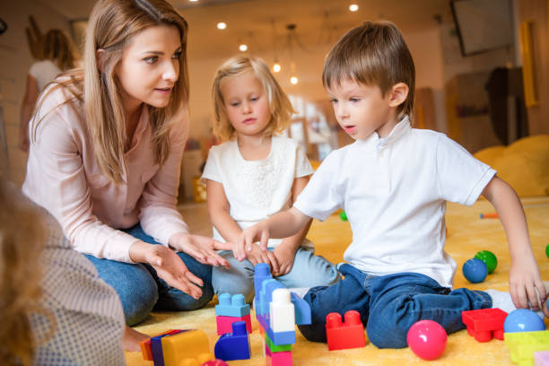 istock educator and caucasian kids playing with constructor in kindergarten 1047041742