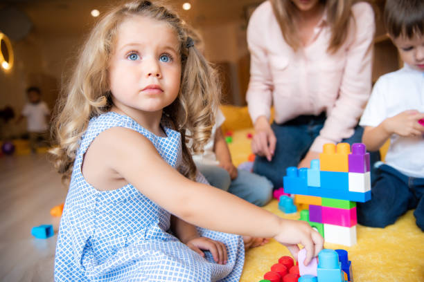 istock adorable kid playing with constructor and looking up in kindergarten 1047041770