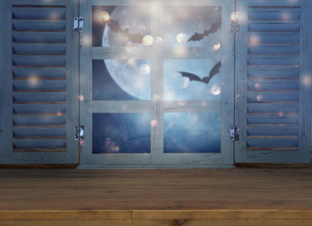 istock Halloween holiday concept. Empty rustic table in front of haunted night sky background and old window. Ready for product display montage 1047053862