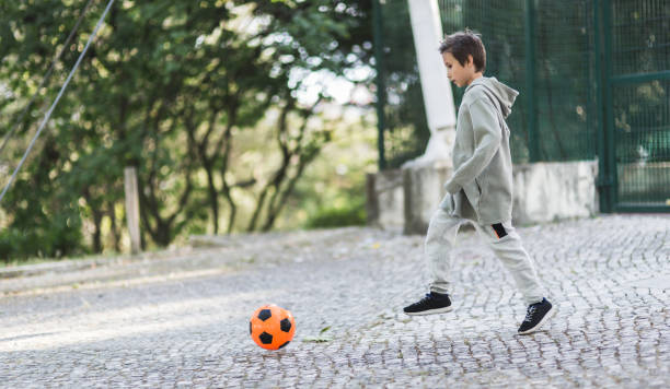 istock Boy play with football ball 1047054472