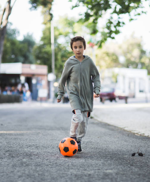 istock Boy play with football ball 1047054480