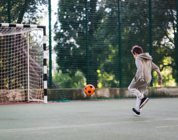 istock Boy play with football ball 1047054486