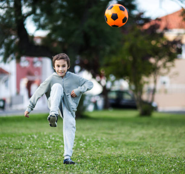istock Boy play with football ball 1047054490