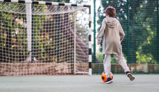 istock Boy play with football ball 1047054500