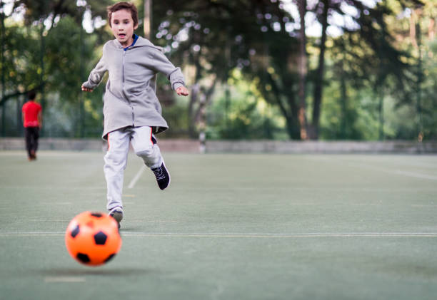 istock Boy play with football ball 1047054502