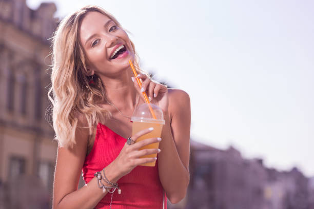 istock Delighted blonde woman holding a plastic straw 1047054790