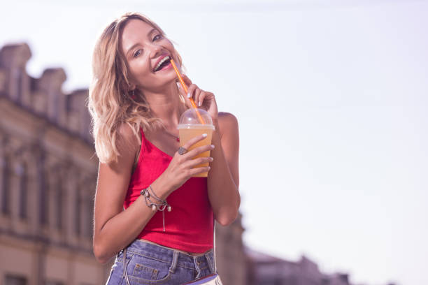 istock Delighted nice woman enjoying her tasty drink 1047054810