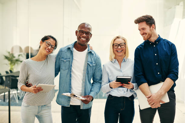 istock Diverse young businesspeople laughing together in a bright modern office 1047055292