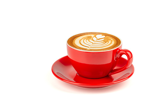 Café con leche caliente con arte del latte en una taza roja brillante y plato aislado sobre fondo blanco con trazado de recorte dentro de. photo