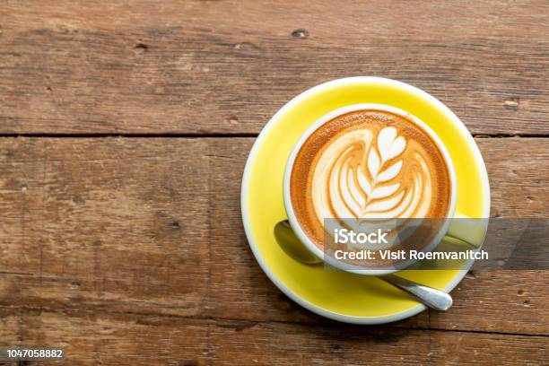 Draufsicht Der Heißen Cappuccino Kaffee In Einer Gelben Schale Mit Latte Art Auf Holztisch Hintergrund Stockfoto und mehr Bilder von Kaffee - Getränk
