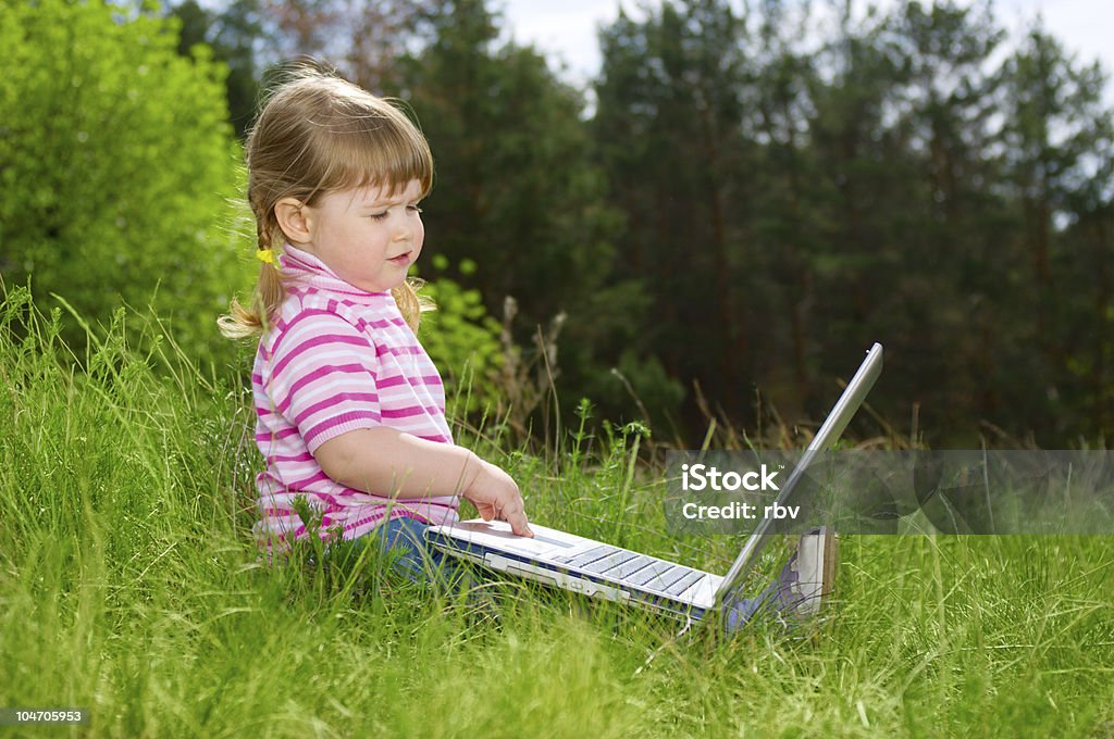 Petite fille avec un ordinateur portable - Photo de Assis libre de droits