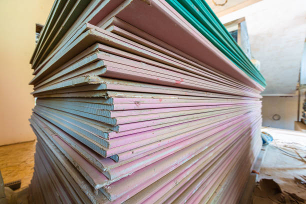 Construction materials and sheets of plasterboard or drywall are prepared for working process of installing plasterboard -drywall -for making gypsum walls in apartment is under construction, remodeling, renovation, extension, restoration and reconstruction materiales de construcción y láminas de cartón yeso o paneles de yeso se preparan para el proceso de instalación de escayola-yeso-para hacer paredes de yeso en apartamento está en construcción, remodelación, restauración, ampliación, restauración