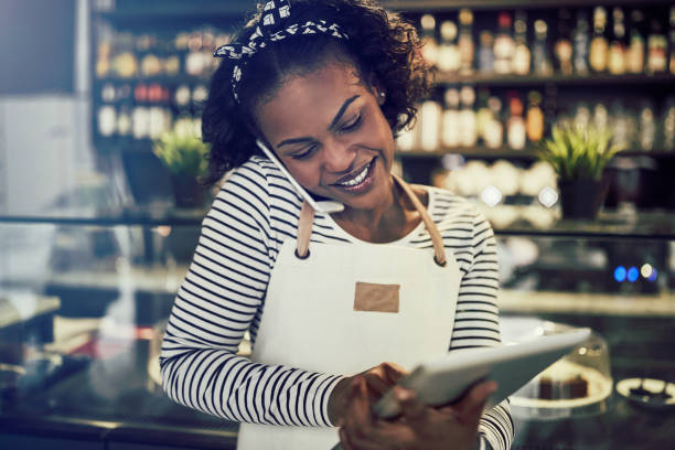 istock Young African cafe owner taking reservations over the phone 1047062362