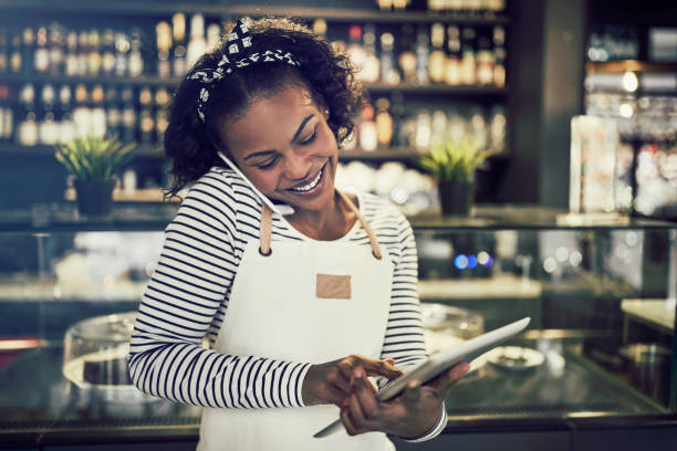istock Young African entrepreneur busy taking reservations in her cafe 1047062444