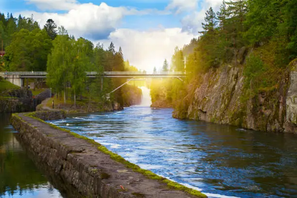 Bridge above the river and waterfall. View of the Telemark Canal with old locks - tourist attraction in Skien, Norway