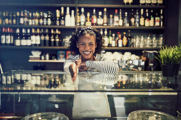 istock Friendly African entrepreneur shaking hands from behind a cafe counter 1047064712