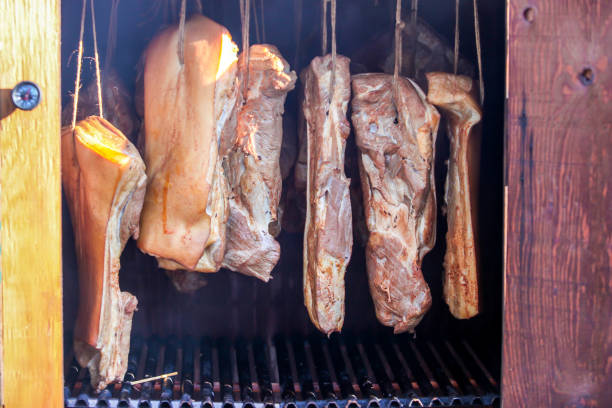 istock Smoked bacon hanging in wooden smoker 1047076190