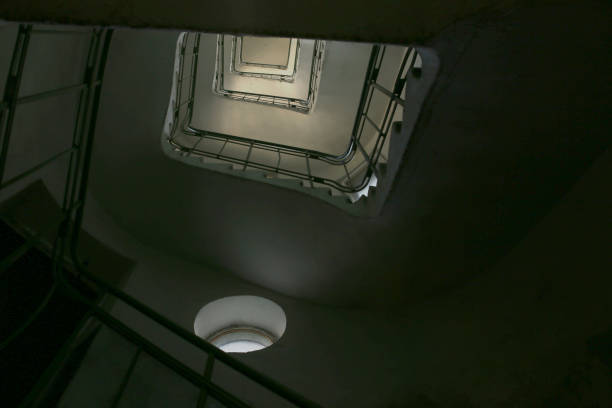 istock Upward spiral vintage staircase in old building from bottom. 1047080116
