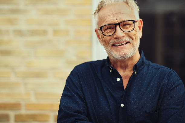 istock Laughing senior man standing in his yard at home 1047082370