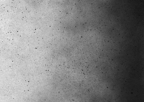 Subtle grain texture. Abstract black and white gritty grunge background. Dark paint spray particles on paper