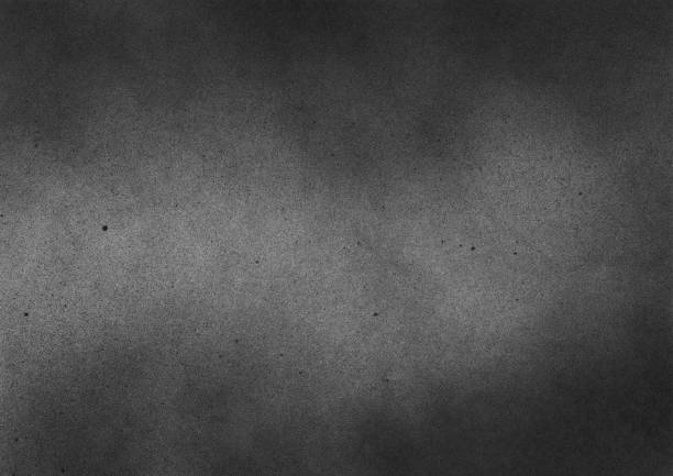 istock Subtle grain texture. Abstract black and white gritty grunge background. Dark paint spray particles on paper 1047083366