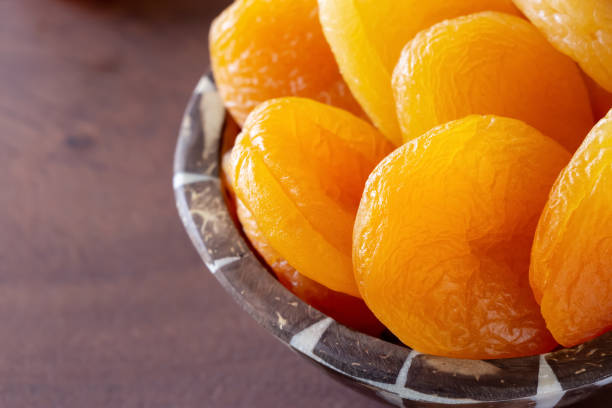 turque de jumbo abricots secs dans un bol en bois. concept de collation santé. gros plan. - dried apricot photos et images de collection