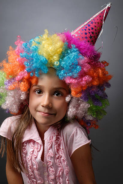 istock Girl in clown's wig with a cone hat making faces 104709393