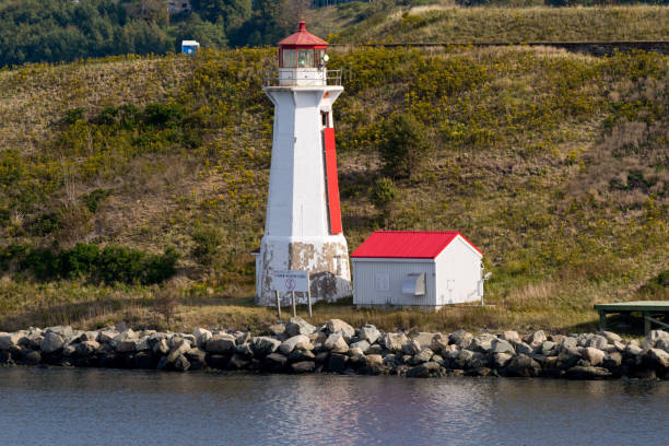 istock Red and white lighthouse along Nova Scotia coastline 1047095480