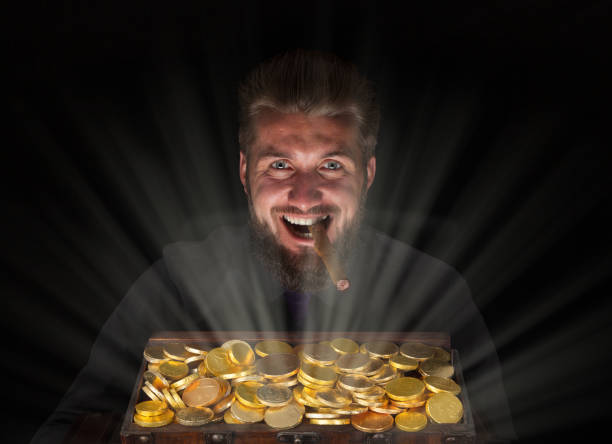 привлекательный деловой человек с с�ундуком с сокровищами, полным золота - greed currency men happiness стоковые фото и изображения