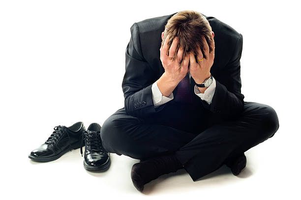 istock Depressed businessman sitting on floor with head in hands 104710528