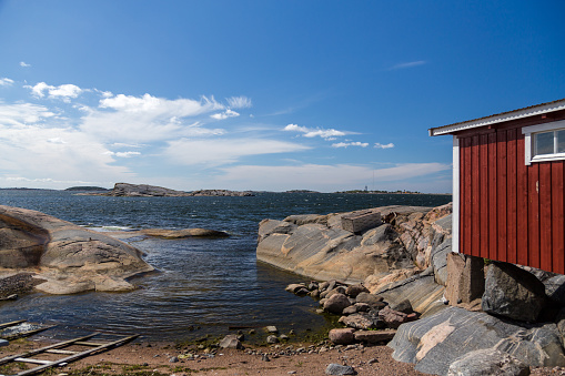 Seaside view at the Gunnarsinranta shore of Hanko Finland by the old red fishermans huts