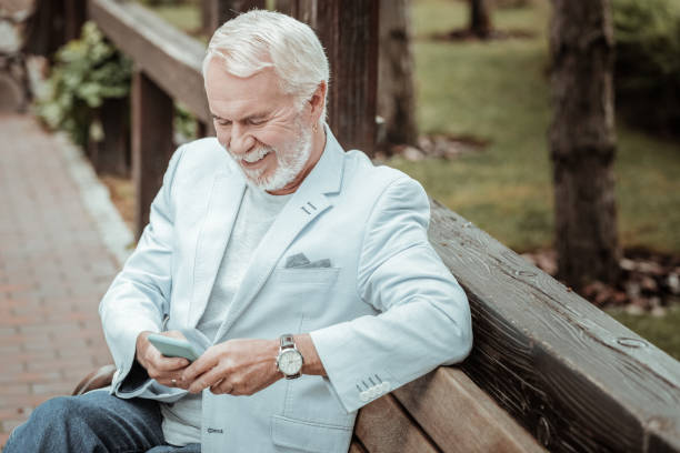 cheerful male person keeping smile on his face - senior adult human face male action imagens e fotografias de stock