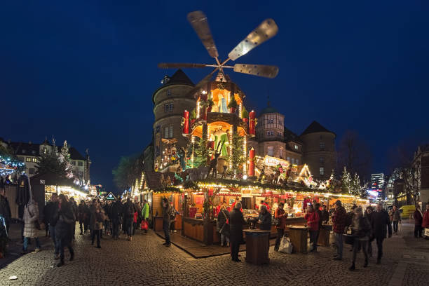 Christmas market with Christmas pyramid close to Old Castle in Stuttgart, Germany Stuttgart, Germany - December 14, 2017: Christmas market with Christmas pyramid close to Altes Schloss (Old Castle) in dusk. Unknown people walk around the market stalls and buy food and drinks. The Christmas pyramid is a kind of carousel demonstrating nativity scenes. stuttgart photos stock pictures, royalty-free photos & images