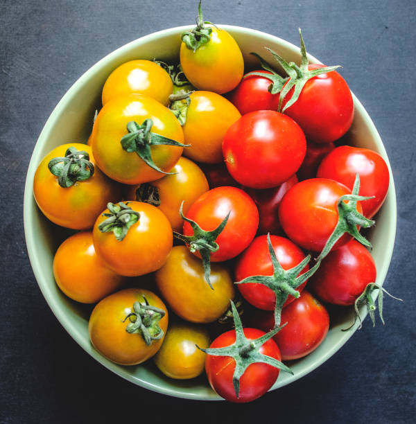 istock Cherry tomatoes on a dark background with olive branches 1047116642