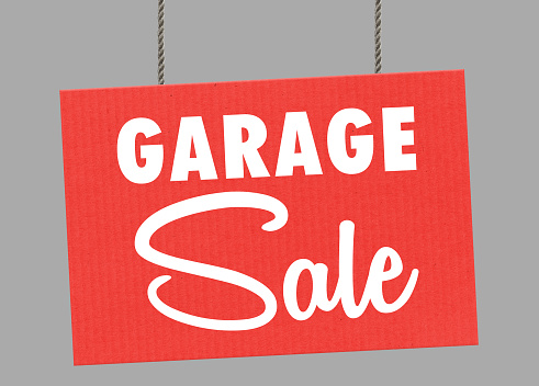 Cardboard garage sale sign hanging from ropes. Clipping path included so you can put your own background
